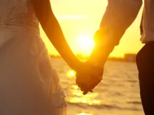 Married couple holding hands. Stock image: szefei/Shutterstock