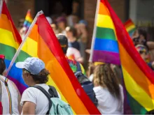 People with rainbows flags in the annual Pride Parade as it passes through Greenwich Village. Via Shutterstock.