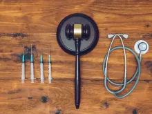 Syringes, stethoscope and judge gavel on wooden background. 
