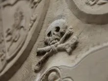 Memento mori skull on a marble wall. 