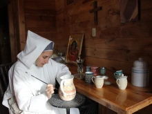 A religious sister from the Monastery of Bethlehem in Livingston Manor, New York, hand-paints a pitcher.