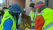 Volunteers prepare and distribute food to families coming through the drive-through distribution site at the Catholic Charities Diocese of Galveston-Houston Guadalupe Center, a food pantry near central Houston.