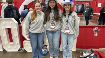 Lucy Snipes, Anne Young, and Presley Hilderbrand from Columbus, Georgia tour exhibits during the first night of NCYC 2025 on Nov. 20, 2025, at the Indiana Convention Center in Indianapolis.