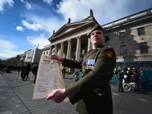 An Irish soldier holds the a copy of the 1916 Proclamation of the Irish Republic outside the General Post Office, the scene of the 1916 Easter Rising, in Dublin on March 27, 2016 as part of a program of commemorative events to mark the 100th anniversary of the Easter Rising.