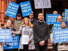 Isabel Vaughan-Spruce (center-left) and Father Sean Gough (center-right) celebrate their legal win outside the Birmingham Magistrates Court in Birmingham, England, on Feb. 16, 2023.