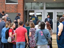 St. Louis metropolitan police and school officials stand outside the south entrance to the Central Visual and Performing Arts High School after a shooting that left three people dead including the shooter in St Louis, Missouri on Oct. 24, 2022.