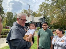 Bishop Michael Martin of Charlotte, North Carolina, greets a young Catholic while surveying storm damage at Swannanoa, North Carolina, Friday, on Oct. 4, 2024.