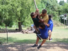 Boys swing on a rope during recess at Western Academy in Houston, Texas.