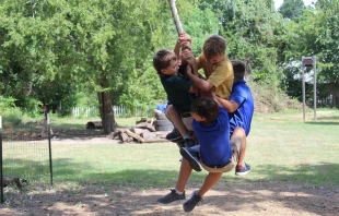 Boys swing on a rope during recess at Western Academy in Houston, Texas. Credit: Courtesy of Western Academy