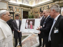 Pope Leo XIV views a display of headlines on his election to the pontificate during a meeting with the MINDS Conference in Rome, Thursday, Oct. 9, 2025.