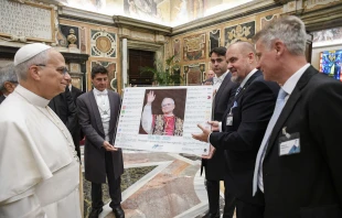 Pope Leo XIV views a display of headlines on his election to the pontificate during a meeting with the MINDS Conference in Rome, Thursday, Oct. 9, 2025. Credit: Vatican Media