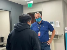 Antonio Fernandez, CEO of Catholic Charities San Antonio, aids a migrant following the death of dozens of people abandoned in a truck.