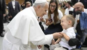 Pope Leo XIV greets sick and disabled people, including a young child in a wheelchair, in the Vatican’s Paul VI Hall after the Wednesday general audience on Sept. 10, 2025.