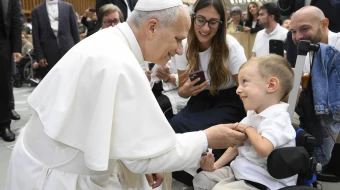 Pope Leo XIV greets sick and disabled people, including a young child in a wheelchair, in the Vatican’s Paul VI Hall after the Wednesday general audience on Sept. 10, 2025.