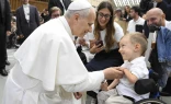 Pope Leo XIV greets sick and disabled people, including a young child in a wheelchair, in the Vatican’s Paul VI Hall after the Wednesday general audience on Sept. 10, 2025.