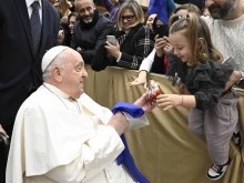 During his audience with Italian Catholic educators, Pope Francis interacts with a young girl at the Paul VI Audience Hall at the Vatican on Jan. 4, 2025.