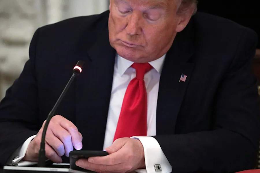  U.S. President Donald Trump works on his phone during a roundtable at the State Dining Room of the White House June 18, 2020 in Washington, DC. ?w=200&h=150