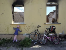 A young girl draws on the wall of a destroyed house in the village of Andriivka, Kyiv region, on June 3, 2022 on the 100th day of the Russian invasion of Ukraine. Sergei Chuzavkov/AFP via Getty Images)