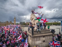 Protesters wave the Union Jack and St. George’s Cross flags during the “Unite the Kingdom” rally on Westminster Bridge by the Houses of Parliament on Sept. 13, 2025, in London.