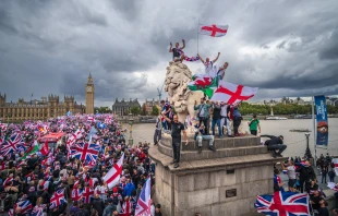 Protesters wave the Union Jack and St. George’s Cross flags during the “Unite the Kingdom” rally on Westminster Bridge by the Houses of Parliament on Sept. 13, 2025, in London. Credit: Christopher Furlong/Getty Images