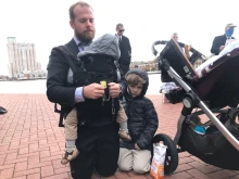 Gabriel Vance, of Columbus, Ohio, prays the rosary, with his three young sons beside him, at the pro-life Men's March in Baltimore on Nov. 15, 2021.