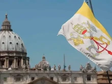 The Vatican flag and the dome of St. Peter's Basilica.