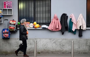  A woman walks past a "Wall of Kindness,” a charity work phenomenon, encouraging people to items such as winter clothing for the homeless, on Jan 25, 2020 in Milan.   MIGUEL MEDINA/AFP via Getty