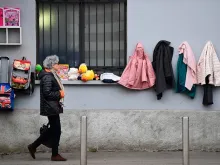  A woman walks past a "Wall of Kindness,” a charity work phenomenon, encouraging people to items such as winter clothing for the homeless, on Jan 25, 2020 in Milan. 
