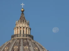 The moon is visible over St. Peter's Basilica, Vatican, on the morning of Oct. 12, 2022.