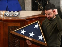 Ukraine's President Volodymyr Zelensky receives from U.S. House Speaker Nancy Pelosi (D-CA) (L) a US national flag during his address to the U.S. Congress at the U.S. Capitol in Washington, D.C. on Dec. 21, 2022.