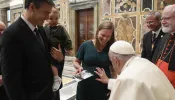 Pope Francis blesses an unborn baby during the Papal Foundation's annual pilgrimage in Rome on Friday, April 12, 2024.