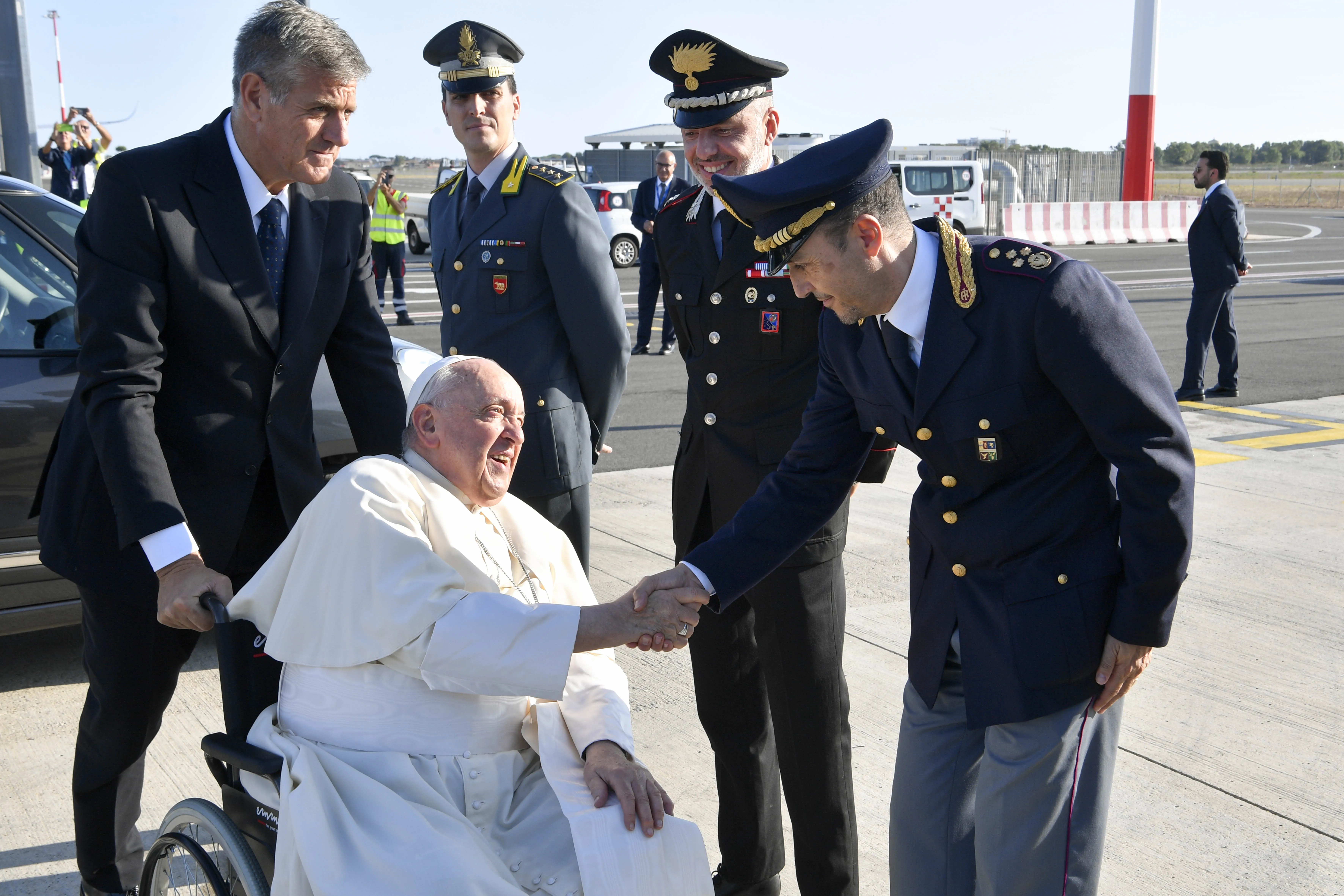 Pope Francis greets airline workers as he boards the papal plane for his four-day trip to Mongolia on Aug. 31, 2023.?w=200&h=150