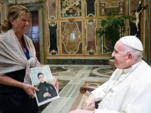 Susan Agostinelli shows Pope Francis a picture of her great, great uncle, Bl. Grimoaldo Santamaria of the Purification, during a meeting at the Vatican on Oct. 6, 2022. The audience was part of a conference on holiness and sainthood hosted by the Vatican.