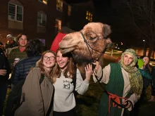 Students at The Catholic University of America posing with Delilah the Camel at the school's annual "Greccio" live nativity event on Dec. 12, 2021.