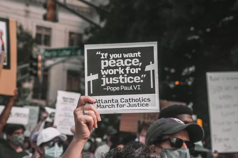 A participant holds up a sign with a quote from St. Paul VI at a June 2020 rally in Atlanta. Credit: Maria Oswalt via Unsplash.?w=200&h=150
