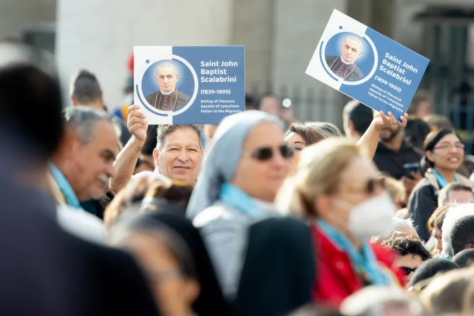 Pilgrims hold signs with image of St. Giovanni Battista Scalabrini at his canonization on Oct. 9, 2022