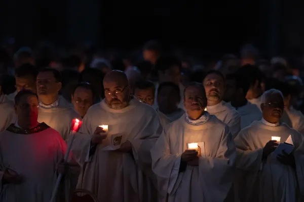 The Easter Vigil liturgy begins in darkness. Forty cardinals, 25 bishops, and about 200 priests processed through the dark church carrying lit candles to signify the light of Christ coming to dispel the darkness. Daniel Ibanez/CNA