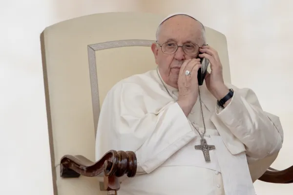 Pope Francis interrupted his general audience on May 17, 2023 to answer a phone call. Daniel Ibanez/CNA