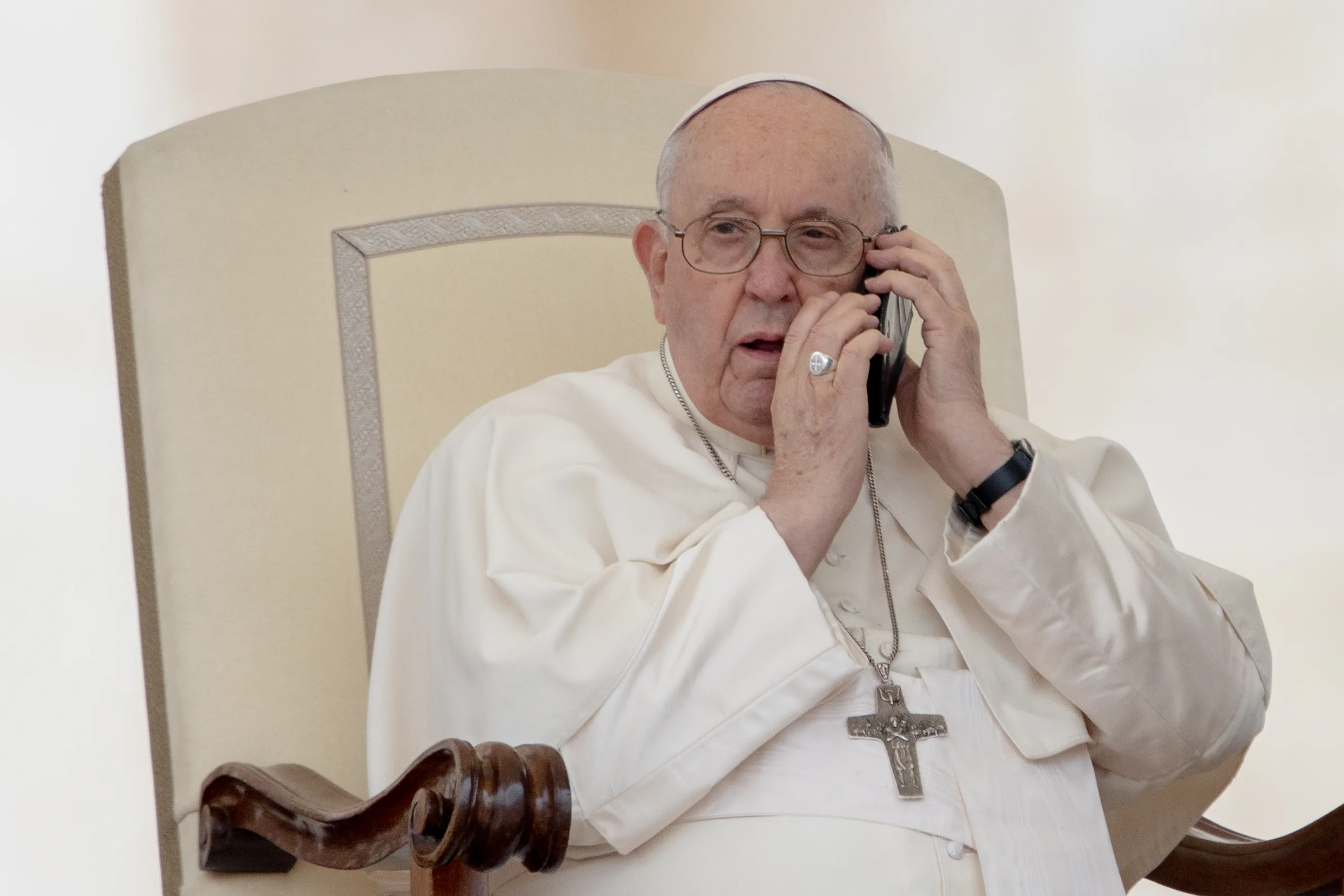 Pope Francis receives phone call during general audience