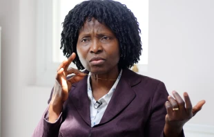 Nurse Mary Onuoha holds the cross on her necklace. Christian Concern.