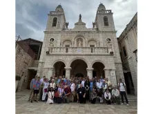 Father Björn Lundberg, center, with the tour group he led to the Holy Land in front of the Wedding Church at Cana.