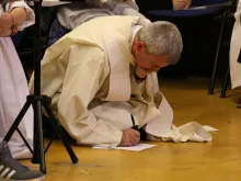 A priest writing a letter to St. Therese of Lisieux during a "rose petals" evening of prayer in Vismara, province of Milan, Italy, September 2017.