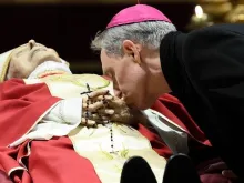 Archbishop Georg Gänswein bent down to kiss the hands of his friend and mentor, Pope Emeritus Benedict XVI.