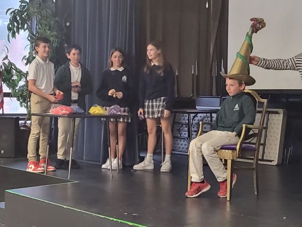 A St. Alphonsus student gets sorted into his "house." Eighth grade house captains are pictured in the background. Credit: Melissa Rodriguez-Murphy