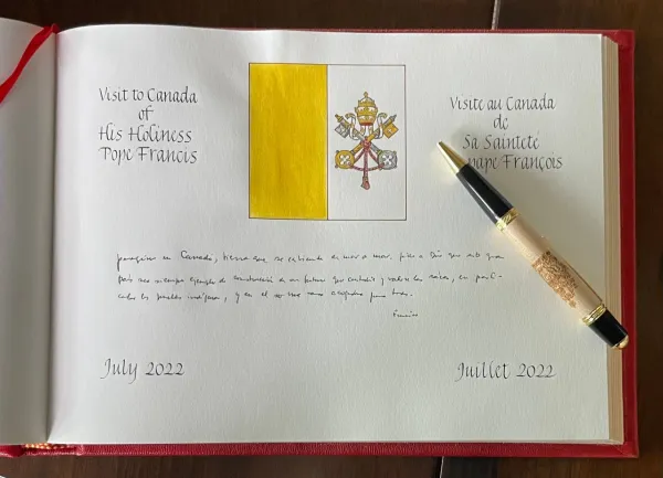 Pope Francis signs a book of honor in Quebec, Canada, July 27, 2022. Holy See Press Office