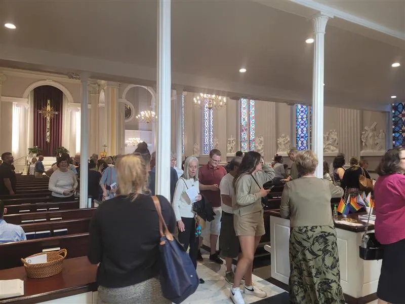 Crowds exit Holy Trinity Catholic Church in Washington, D.C., after the June 14, 2023, "Pride Mass" with "Progress Pride" flags visible in the back of the church.?w=200&h=150