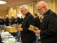 Archbishop Paul Coakley of Oklahoma City (Left) and Bishop James Wall of Gallup (Right) pray before the afternoon session of the 2019 USCCB General Assembly, June 12, 2019.