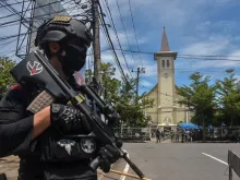An Indonesian policeman stands guard outside a church after an explosion in Makassar on March 28, 2021.