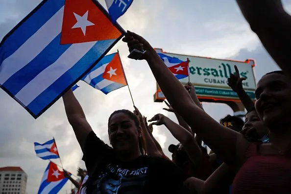 People demonstrate, some holding Cuban flags, during a protest against the Cuban government at Versailles Restaurant in Miami, on July 12, 2021. - Havana on Monday blamed a US "policy of economic suffocation" for unprecedented protests against Cuba's communist government as Washington pointed the finger at "decades of repression" in the one-party state. Credit: Eva Marie Uzcategui/AFP via Getty Images.?w=200&h=150