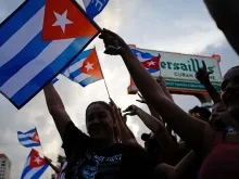 People demonstrate, some holding Cuban flags, during a protest against the Cuban government at Versailles Restaurant in Miami, on July 12, 2021. - Havana on Monday blamed a US "policy of economic suffocation" for unprecedented protests against Cuba's communist government as Washington pointed the finger at "decades of repression" in the one-party state. Credit: Eva Marie Uzcategui/AFP via Getty Images.